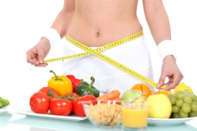 Mädchen misst Taille vor Lebensmittelgeschäft-Hintergrund